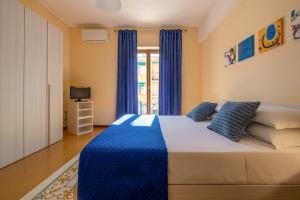a bedroom with a large bed with blue curtains at Marziale Luxury Apartment in Sorrento +31 photos