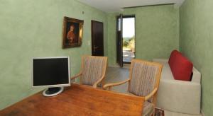 ein Wohnzimmer mit Fernseher und Tisch und Stühlen in der Unterkunft Chalet Charbonnier in Wolpadingen