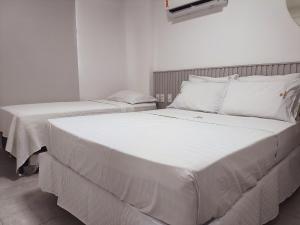 a bedroom with two beds with white sheets at Ap 2Q Beira-Mar ao lado do Food Park Cabo Branco in João Pessoa +42 photos