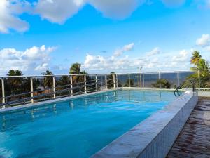 a swimming pool with a view of the ocean at Ap 2Q Beira-Mar ao lado do Food Park Cabo Branco in João Pessoa