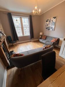 un salon avec un canapé et une table dans l'établissement John Knox's Apartment on Edinburgh's Royal Mile, à Édimbourg