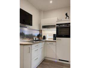 a white kitchen with white cabinets and appliances at Ferienwohnung Kleine Auszeit in Neuhaus