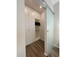 a hallway with white cabinets and a walk in closet at Ferienwohnung Kleine Auszeit in Neuhaus +16 photos