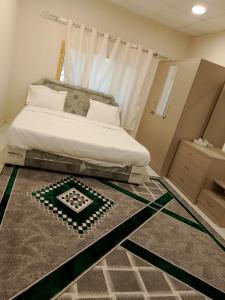 Green Resort Hotel AL khaburah في As Sarhāt: غرفة نوم صغيرة بها سرير وسجادة