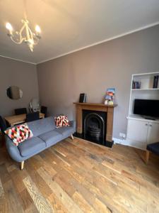 un salon avec un canapé et une cheminée dans l'établissement John Knox's Apartment on Edinburgh's Royal Mile, à Édimbourg