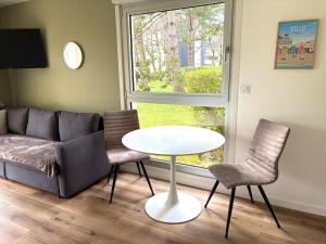 a living room with a couch and a table and chairs at Studio 4 people Stella beach in Cucq