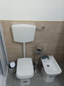 a bathroom with a white toilet and a sink at LA casetta 2.0 in Termini Imerese