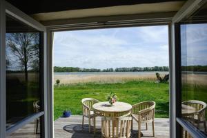 a table and chairs on a porch with a view of a lake at Ferienhaus Remise 6 Personen mit Terrasse in Neuenkirchen