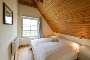 a bedroom with a large bed and a window at Ferienhaus Remise 6 Personen mit Terrasse in Neuenkirchen
