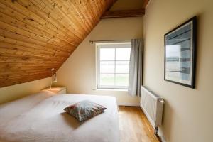 a bedroom with a large bed and a window at Ferienhaus Remise 6 Personen mit Terrasse in Neuenkirchen +6 photos