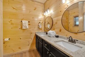 a bathroom with a sink and a mirror at Honeybear Hideaways - Luxury Gatlinburg Smoky Cabin with Indoor Pool and Hot Tub in Gatlinburg