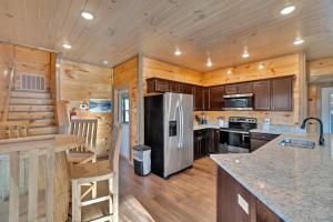 a kitchen with a stainless steel refrigerator and wooden walls at Honeybear Hideaways - Luxury Gatlinburg Smoky Cabin with Indoor Pool and Hot Tub in Gatlinburg