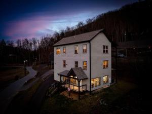 a large white house with its lights on at Honeybear Hideaways - Luxury Gatlinburg Smoky Cabin with Indoor Pool and Hot Tub in Gatlinburg