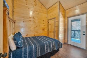 a bedroom with a bed in a wooden room at Honeybear Hideaways - Luxury Gatlinburg Smoky Cabin with Indoor Pool and Hot Tub in Gatlinburg
