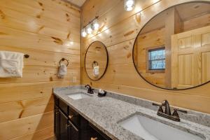 a bathroom with a sink and a mirror at Honeybear Hideaways - Luxury Gatlinburg Smoky Cabin with Indoor Pool and Hot Tub in Gatlinburg