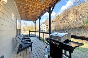 a covered porch with a grill and a bench at Honeybear Hideaways - Luxury Gatlinburg Smoky Cabin with Indoor Pool and Hot Tub in Gatlinburg