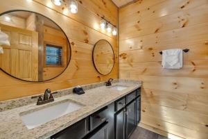 a bathroom with two sinks and a mirror at Honeybear Hideaways - Luxury Gatlinburg Smoky Cabin with Indoor Pool and Hot Tub in Gatlinburg
