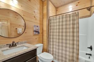 a bathroom with a toilet and a sink and a mirror at Honeybear Hideaways - Luxury Gatlinburg Smoky Cabin with Indoor Pool and Hot Tub in Gatlinburg