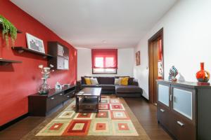sala de estar con sofá y pared roja en Retiro rural con parking by CABANA Rentals, en Vigo