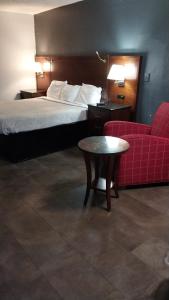 a hotel room with a bed and a red couch at King Bed Hotel Room 152 in Jackson
