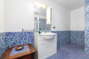 Un baño con azulejos azules, lavabo y espejo. en Retiro rural con parking by CABANA Rentals, en Vigo 30 fotos más