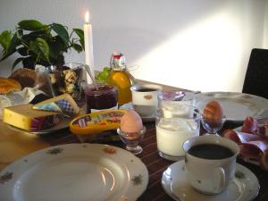 a table with plates and cups of milk and eggs at Ferienwohnung in Preußisch Oldendorf in Preußisch Oldendorf