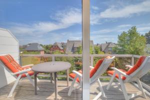 d'un balcon avec deux chaises, une table et une table. dans l'établissement Windeby 3D, à Wenningstedt