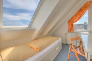une petite chambre avec un lit et une fenêtre dans l'établissement Windeby 3D, à Wenningstedt