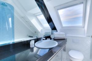 une salle de bain avec un lavabo et des toilettes et une fenêtre dans l'établissement Windeby 3D, à Wenningstedt 15 autres photos