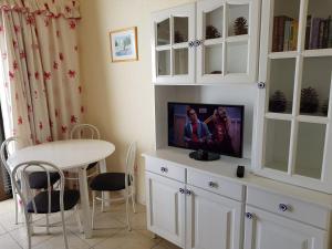 a living room with a tv on a white cabinet at Cool Duplex in Playa las Americas in Playa de las Americas