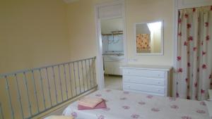 a bedroom with a crib and a dresser and a mirror at Cool Duplex in Playa las Americas in Playa de las Americas +31 photos