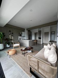 a living room with a white couch and a kitchen at Tropicalia Home - Apartment in Armenia