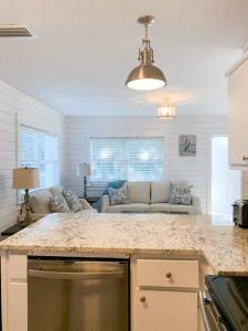 a kitchen with a counter top and a living room at Coastal Condos on the Marsh 5B in Dauphin Island