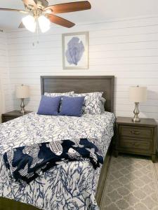 a bedroom with a bed with blue pillows and a ceiling fan at Coastal Condos on the Marsh 5B in Dauphin Island