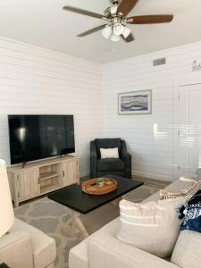 a living room with a couch and a tv at Coastal Condos on the Marsh 6A in Dauphin Island +15 photos
