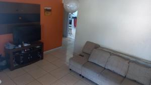 a living room with a couch and a flat screen tv at Alugo para Carnaval in Araruama