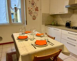 een keuken met een tafel met oranje borden en glazen bij Perfect Point Como in Lecco