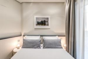 a bedroom with a white bed with two pillows at Petrarca Boutique Apartment - Sofia Apartments in Naples