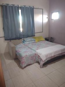 a bedroom with a large bed with a blue curtain at Alugo para Carnaval in Araruama +16 photos
