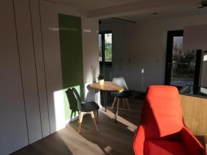 a living room with a red couch and a table at Fewo Blick zum Stern in Wermsdorf