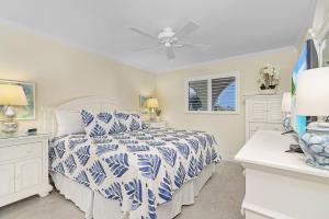 a white bedroom with a bed and a ceiling fan at 3rd Floor Sanibel Condo With Balcony And Beach Views 4B3 in Sanibel