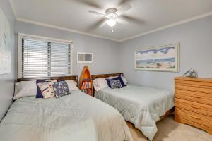 a bedroom with two beds and a ceiling fan at Balcony with Ocean Views Carolina Beach Condo! in Carolina Beach