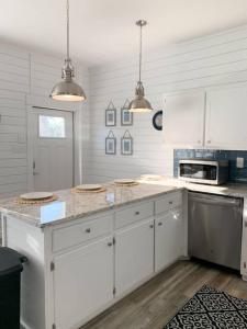 a kitchen with white cabinets and a counter top at Coastal Condos on the Marsh 6B in Dauphin Island