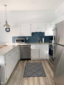 a kitchen with white cabinets and stainless steel appliances at Coastal Condos on the Marsh 6B in Dauphin Island +17 photos