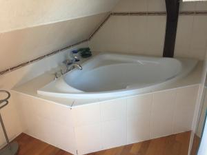 a white bath tub in a white tiled bathroom at Haus Galgenbruch in Feldberg