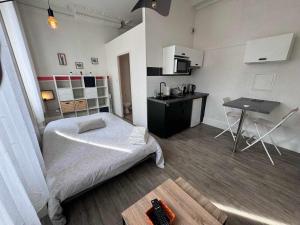 a bedroom with a bed and a table in it at Studio Pont-Canal in Agen
