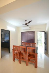 a living room with two benches and a ceiling fan at Centur Apartments in Changanācheri
