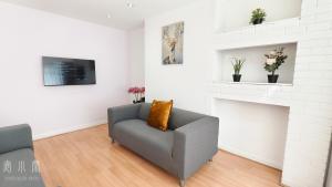 a living room with a couch and a fireplace at 4 Bedroom House with Garden & Parking in Ruislip in South Ruislip Station