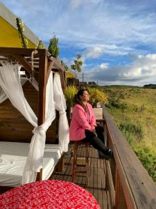 Eine Frau, die auf dem Deck eines Verehrers sitzt. in der Unterkunft Vale de cambara II in Cambará