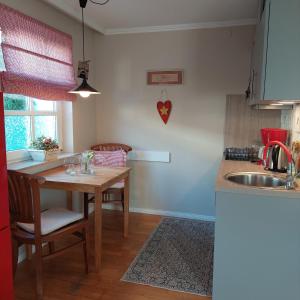 a kitchen with a wooden table and a sink at "NordWest" Ferienwohnung in Prerow